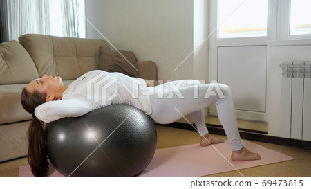pretty girl does abdominal crunches on fitball at home 69473815