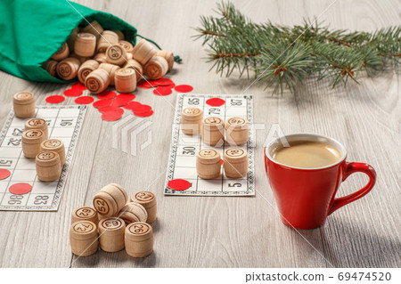 Wooden lotto barrels with bag, game cards, red chips, cup of coffee Wooden lotto barrels with bag, game cards, red chips, cup of coffee 69474520
