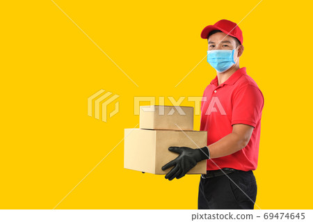 Asian delivery man in red uniform, medical face mask, protective gloves carry cardboard box in hand Asian delivery man in red uniform, medical face mask, protective gloves carry cardboard box in hand 69474645
