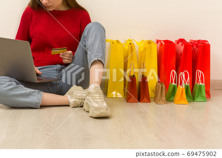 Young woman doing online shopping at home using laptop. 69475902
