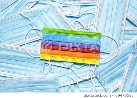 Medical masks pile top view. A rainbow protective mask displayed Medical masks pile top view. A rainbow protective mask displayed 69476555