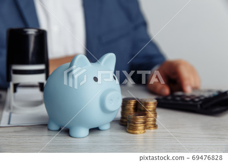 Piggy bank and coins on desk in office. Save money and management financial concept 69476828