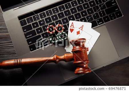 Wooden gavel, playing chips and cards on laptop keyboard. Concept of Law and regulation of gambling Wooden gavel, playing chips and cards on laptop keyboard. Concept of Law and regulation of gambling 69476871