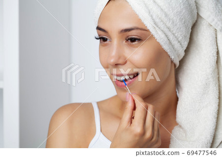 The woman uses brushes to clean the interdental spaces 69477546