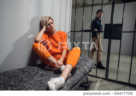 A young pretty blonde prisoner in a general regime prison is sitting in a solitary cell 69477706