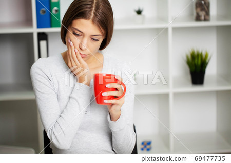 Beautiful young woman suffering from terrible severe toothache, touching cheek with hand. Beautiful young woman suffering from terrible severe toothache, touching cheek with hand. 69477735