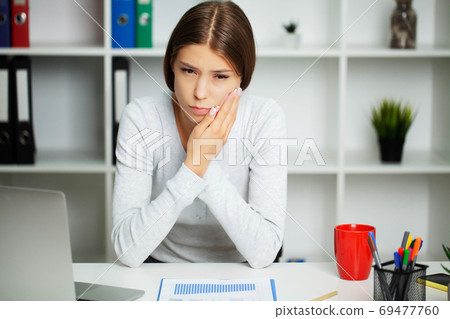 Beautiful young woman suffering from terrible severe toothache, touching cheek with hand. Beautiful young woman suffering from terrible severe toothache, touching cheek with hand. 69477760