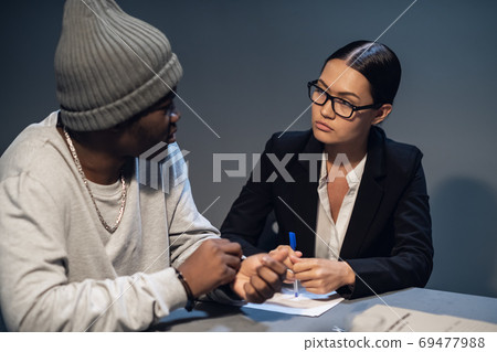 Beautiful girl investigator interrogates a young black man accused of drug distribution Beautiful girl investigator interrogates a young black man accused of drug distribution 69477988