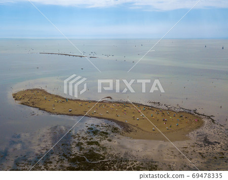 Aerial view of unidentifiable people enjoying a sandbank at the beach of Grado in the province of Gorizia at the Northern Adriatic Sea 69478335