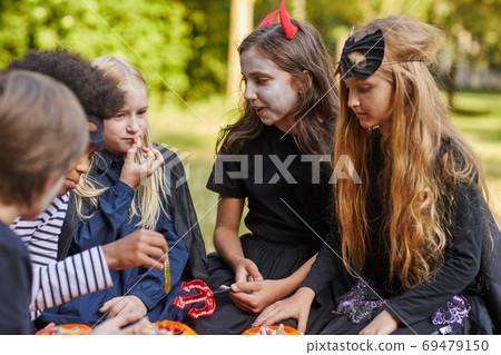 Children Eating Candy on Halloween Children Eating Candy on Halloween 69479150
