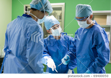 Medical staff performing surgery Medical staff performing surgery 69480050