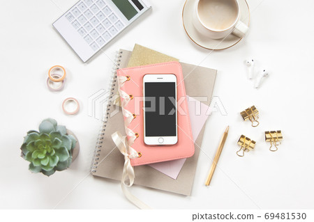 Minimal office desk table with stationery set, coffee cup, earphone and green plant in a pot. 69481530