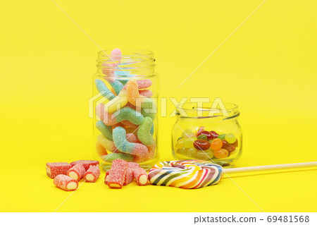 Various colored candies and jellies on a yellow background 69481568
