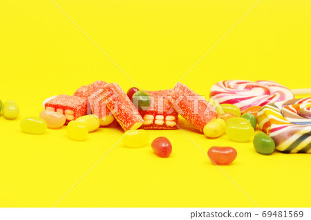 Various colored candies and jellies on a yellow background 69481569