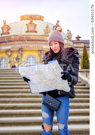 Young female tourist with map looking for a way to Sans Souci pa Young female tourist with map looking for a way to Sans Souci pa 69481576