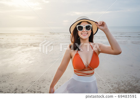 cheerful woman in bikini enjoying on sea beach 69483591