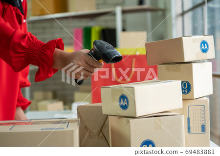 Online seller works at home office and packs shipping delivery box to customer. Online seller works at home office and packs shipping delivery box to customer. 69483881