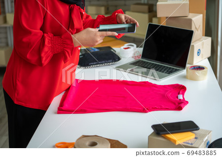 Online seller works at home office and packs shipping delivery box to customer. Online seller works at home office and packs shipping delivery box to customer. 69483885