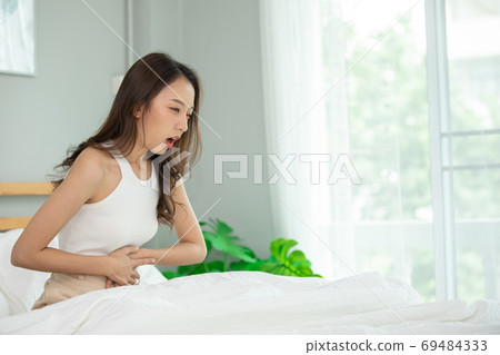 woman have bladder pain and stomach ache sitting on bed in bedroom after wake up feeling so sick and painful,Healthcare concept woman have bladder pain and stomach ache sitting on bed in bedroom after wake up feeling so sick and painful,Healthcare concept 69484333