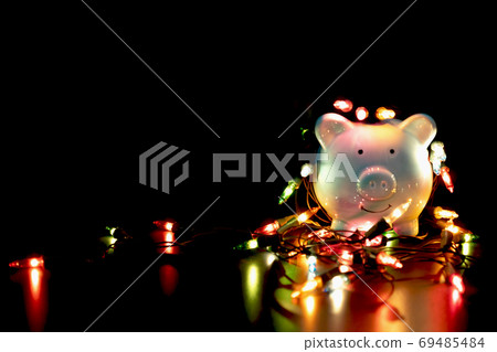 Blue piggy bank with Christmas string lights on happy December festival Blue piggy bank with Christmas string lights on happy December festival 69485484