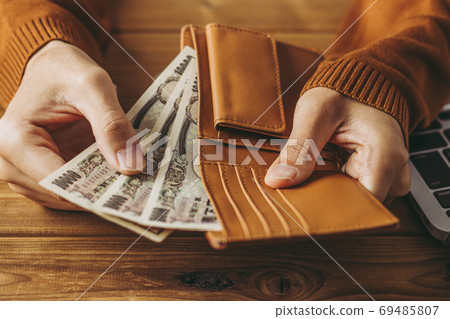 Person paying out of wallet Person paying out of wallet 69485807