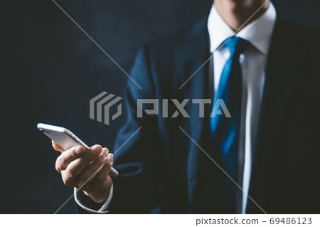 A businessman with a smartphone A businessman with a smartphone 69486123