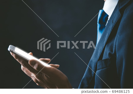 A businessman with a smartphone A businessman with a smartphone 69486125