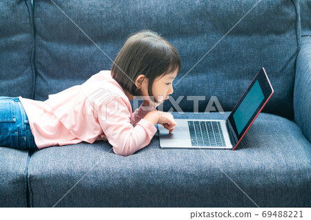 A girl watching a computer A girl watching a computer 69488221