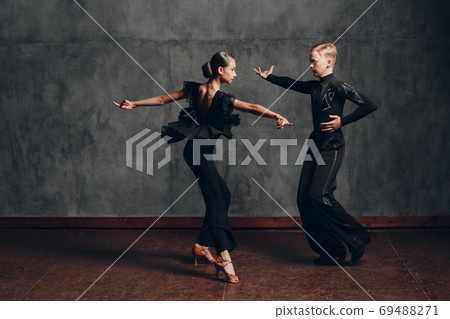 Young couple dancing in ballroom dance cha cha cha. 69488271
