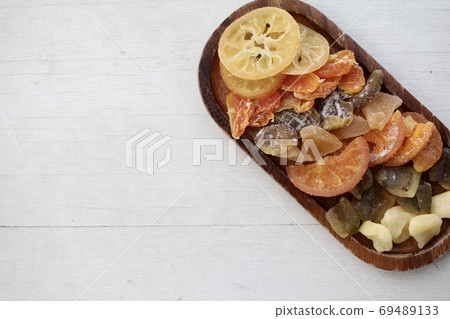 Various kinds of dried fruits arranged on a wooden plate Various kinds of dried fruits arranged on a wooden plate 69489133