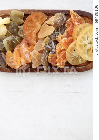 Various kinds of dried fruits arranged on a wooden plate Various kinds of dried fruits arranged on a wooden plate 69489136