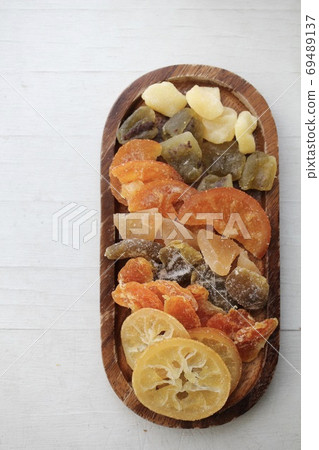 Various kinds of dried fruits on a wooden plate Various kinds of dried fruits on a wooden plate 69489137