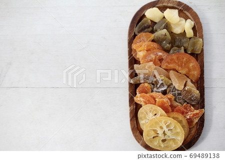 Various kinds of dried fruits on a wooden plate Various kinds of dried fruits on a wooden plate 69489138
