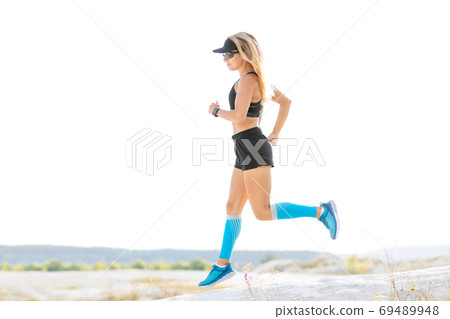Young fitness runner woman jumping on trail path Young fitness runner woman jumping on trail path 69489948