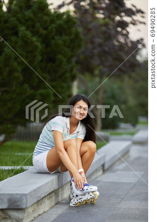 happy woman is wearing roller skates 69490285