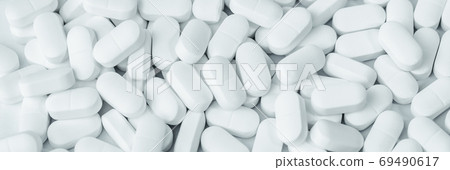Background of white tablets or pills on the table. Medicine and pharmacy Background of white tablets or pills on the table. Medicine and pharmacy 69490617