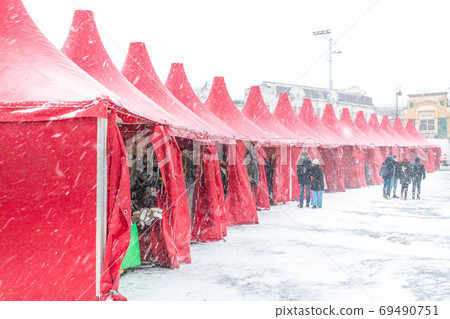 Christmas tents at the downtown fairground during a blizzard 69490751