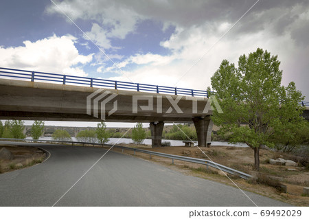 Road passing under a bridge of a highway Road passing under a bridge of a highway 69492029