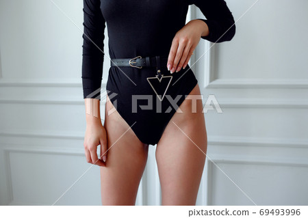 Sexy haughty stylish blonde woman in black bodysuit and cap 69493996