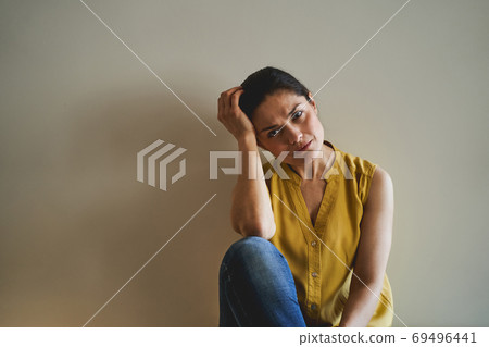 Low-spirited female staring in front of her 69496441
