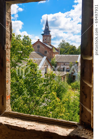 Old abandoned Catholic Church overgrown with greenery 69497931