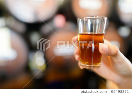 Hand of woman holding drink at old style wine bar Hand of woman holding drink at old style wine bar 69498221