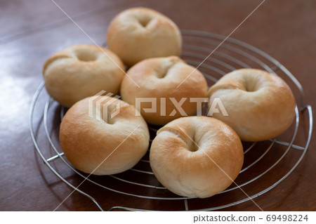 Making bread at home, freshly baked plain bagels lined up on the net Making bread at home, freshly baked plain bagels lined up on the net 69498224