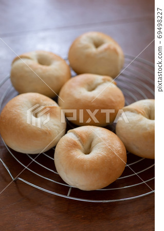 Making bread at home, freshly baked plain bagels lined up on the net 69498227