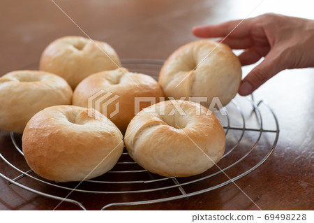 Making bread at home, freshly baked plain bagels lined up on the net 69498228