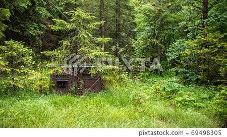 Camouflage hide for nature photography in shadow of a tree inside forest 69498305