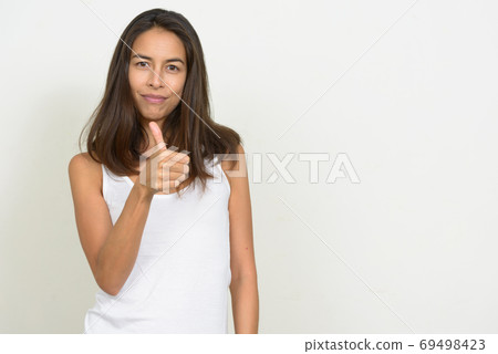 Portrait of happy beautiful multi ethnic woman giving thumbs up Portrait of happy beautiful multi ethnic woman giving thumbs up 69498423