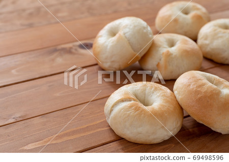 Making bread at home Freshly baked bagels lined up on a styling board 69498596