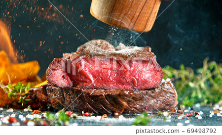 Close-up of tasty beef steak on stone table Close-up of tasty beef steak on stone table 69498792