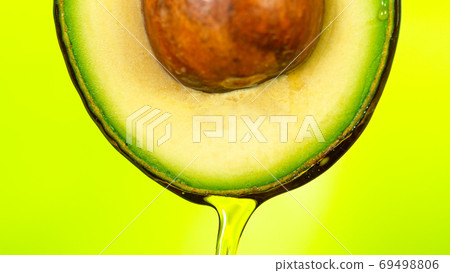 Fresh cut avocado with oil stream. Fresh cut avocado with oil stream. 69498806
